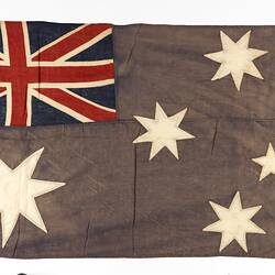 Faded Australian flag with horizontal seam at centre.