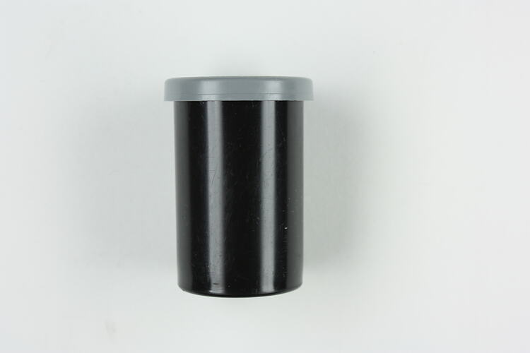 Black plastic canister with grey plastic lid.