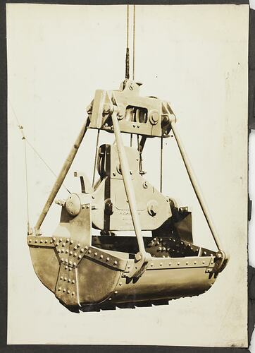 Monochrome photograph of an excavator bucket.