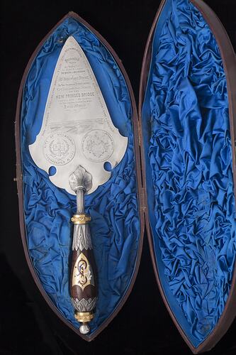 Silver decorative engraved trowel with detailed handle. Blue silk lined box.