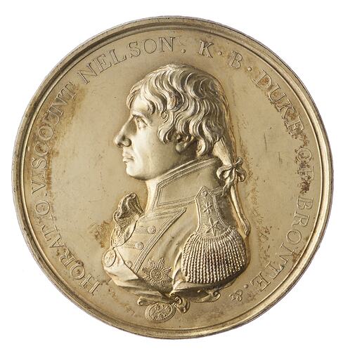 Round gold medal with male facing left. Text around.