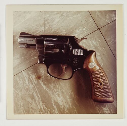 Pistol or hand gun on tiled floor.