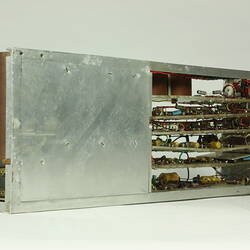 Red control panel with knobs and dials on front of metal box. Case removed to show internal wires and components.