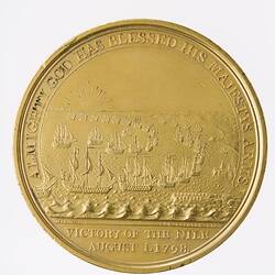 Round medal showing naval battle at sea. Sun rays on horizon.