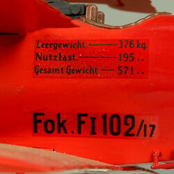Red aeroplane model. Side panel detail with black lettering.