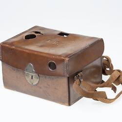 Tan leather camera carry case with strap. Metal clasp at front.