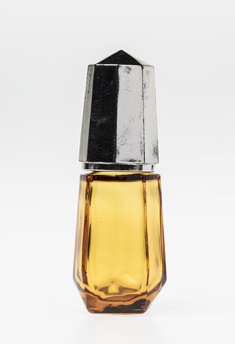 Yellow angular glass bottle with metal lid.