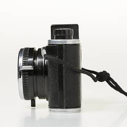 Black camera with metal trim. Wrist strap. Left profile.