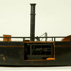 Side view of wooden paddle steamer model.