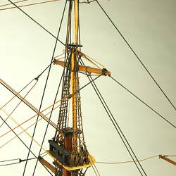 Detail of front mast on model ship, showing crowsnest and rigging.