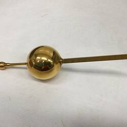 Brass arm and measuring weight.