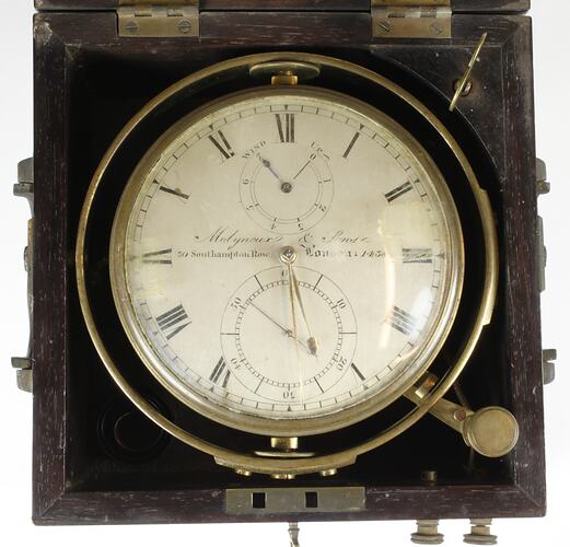 Scientific instrument with glass face and dial inside wooden box.
