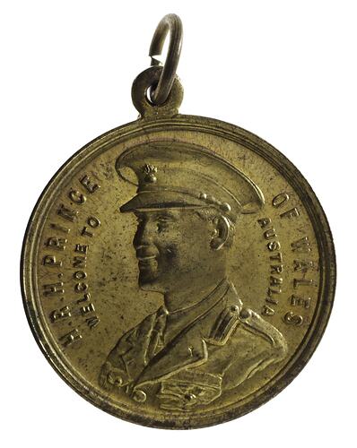 Medal with 3/4 left facing bust of the Prince of Wales in uniform wearing a cap. Text around edge. Loop at top