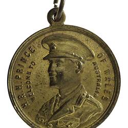 Medal with 3/4 left facing bust of the Prince of Wales in uniform wearing a cap. Text around edge. Loop at top