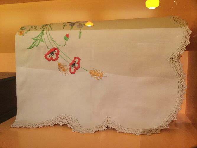 White cloth with embroidered floral design.