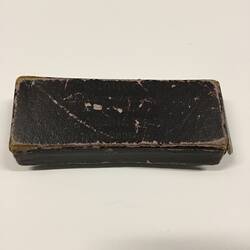 Worn black rectangular box with lid.