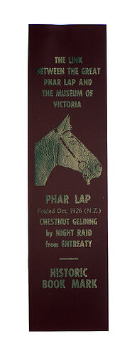 Maroon bookmark with gold horse and text.