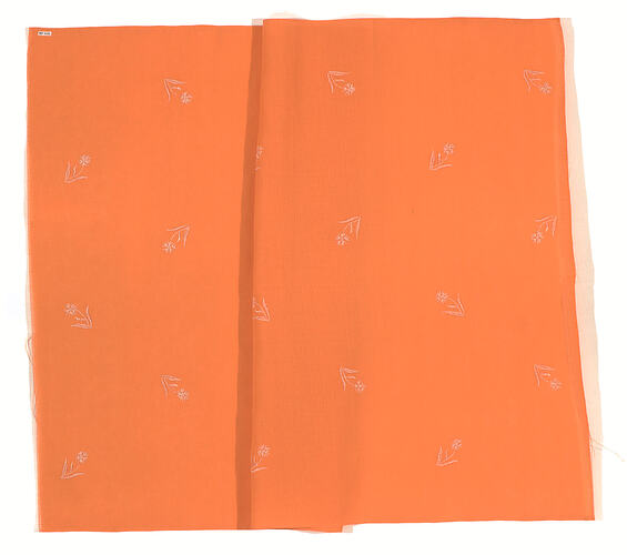 Orange cloth with small white flowers.