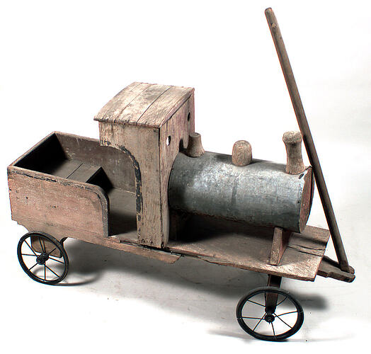 Wooden toy pull along train with four metal and rubber wheels. Stick at front to use as pull along handle.