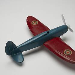 Blue and red toy aeroplane, right, back, three-quarter profile.