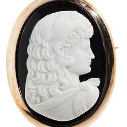 Oval brooch, white cameo of female facing right with black background set in gold border.