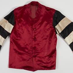 Red riding jacket with red buttons. Black and white hoops on sleeves. Short stand up red collar. Flat.