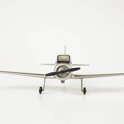 Model aeroplane, silver with a black propeller and wheels.