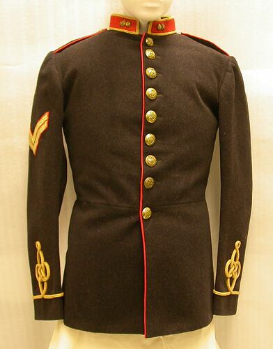 Black uniform jacket with red collar and trim, gold buttons and gold embroidery around sleeves.