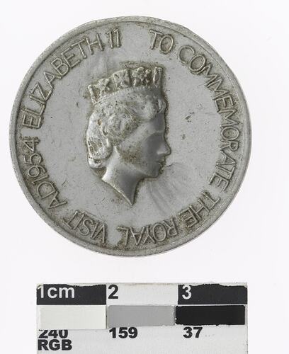 Round silver medal with profile of a crowned woman and text surrounding.
