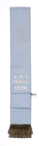 Blue ribbon sash with silver fringe and lettering.
