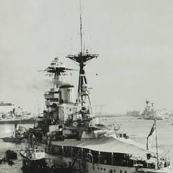 Military battleship with other ships in the background.