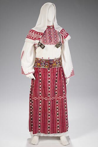 Red and white female ceremonial costume with headscarf.