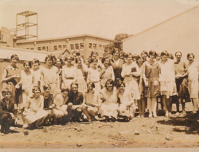 Group of women and boys, posed outside.