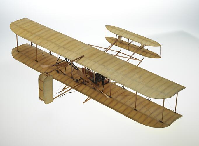 Wooden model aeroplane. Two sets of lacquered fabric wings, front stabilisers, back rudder. Two propellers.
