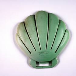 Shell-shaped green plastic form showing maker's name