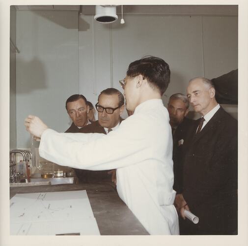 Scientist presenting to group in laboratory.