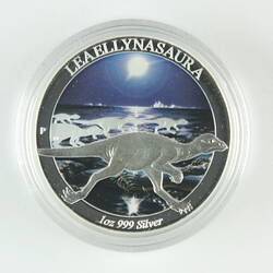Round silver coin showing runnning dinosaur. Coin has dark background.