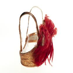 Red feathered brassiere with copper bra, straps. Profile.