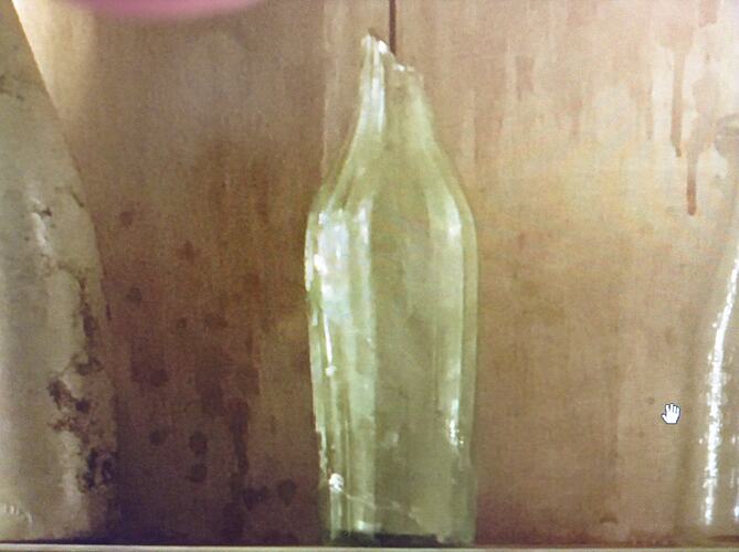 Light green glass bottle,  almost complete. Top missing.