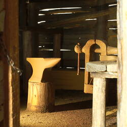 Anvil and bench clamp inside farm smithy model.