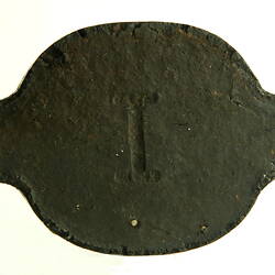 Black briquette with letter "I" stamped.