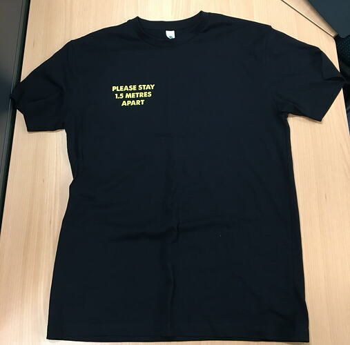 Black tshirt with yellow text in top right hand corner.