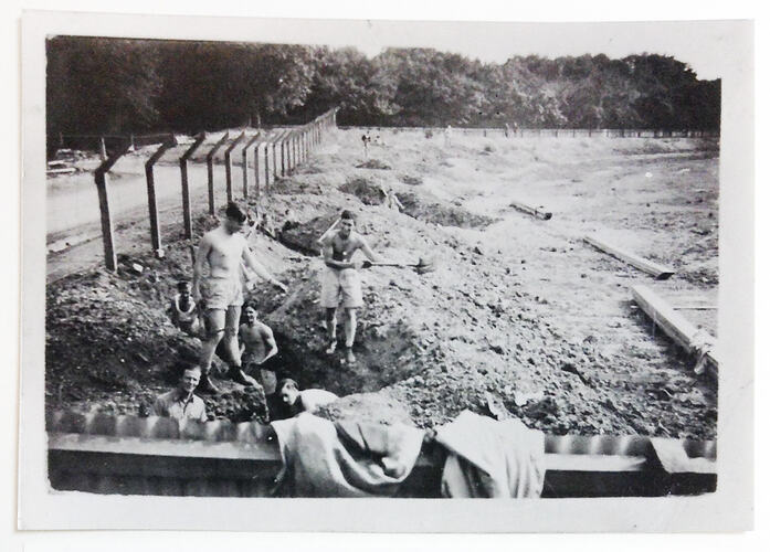 Men next to slit trench.