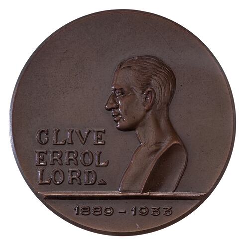 Round medal with profile bust of man. Text beside and below.