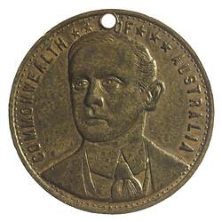 Medal with male bust. Hole at top.