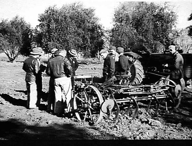 SUNSHINE HELPS YOUNG FARMERS. YOUNG FARMERS AT YANKO WITH FRANK BARRIE (CENTRE OF GROUP) INSPECT A `SUNDUKE' SCARIFIER: `SUNSHINE REVIEW': SEPT 1949