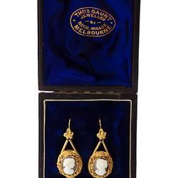 Gold mounted cameo earrings. Round white cameo profile bust with brown background. Navy box.