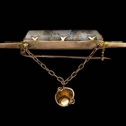 Profile of triple bar brooch with central quartz and gold specimen with small gold bucket attached.