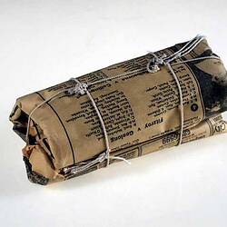 A roll of newspaper tied up with string.