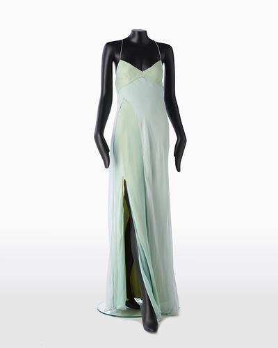 Full length pale green silk evening slip dress. Sleeveless. Flared/fishtail skirt with long slit at right.